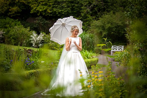 Bride In  Nature holding a white umbrella 
