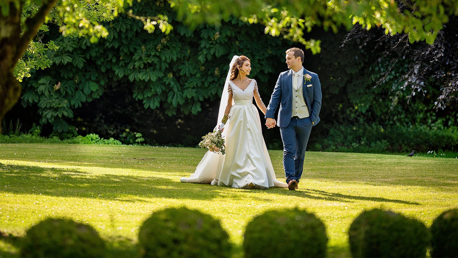 Bride and Groom Walking in Green Field 